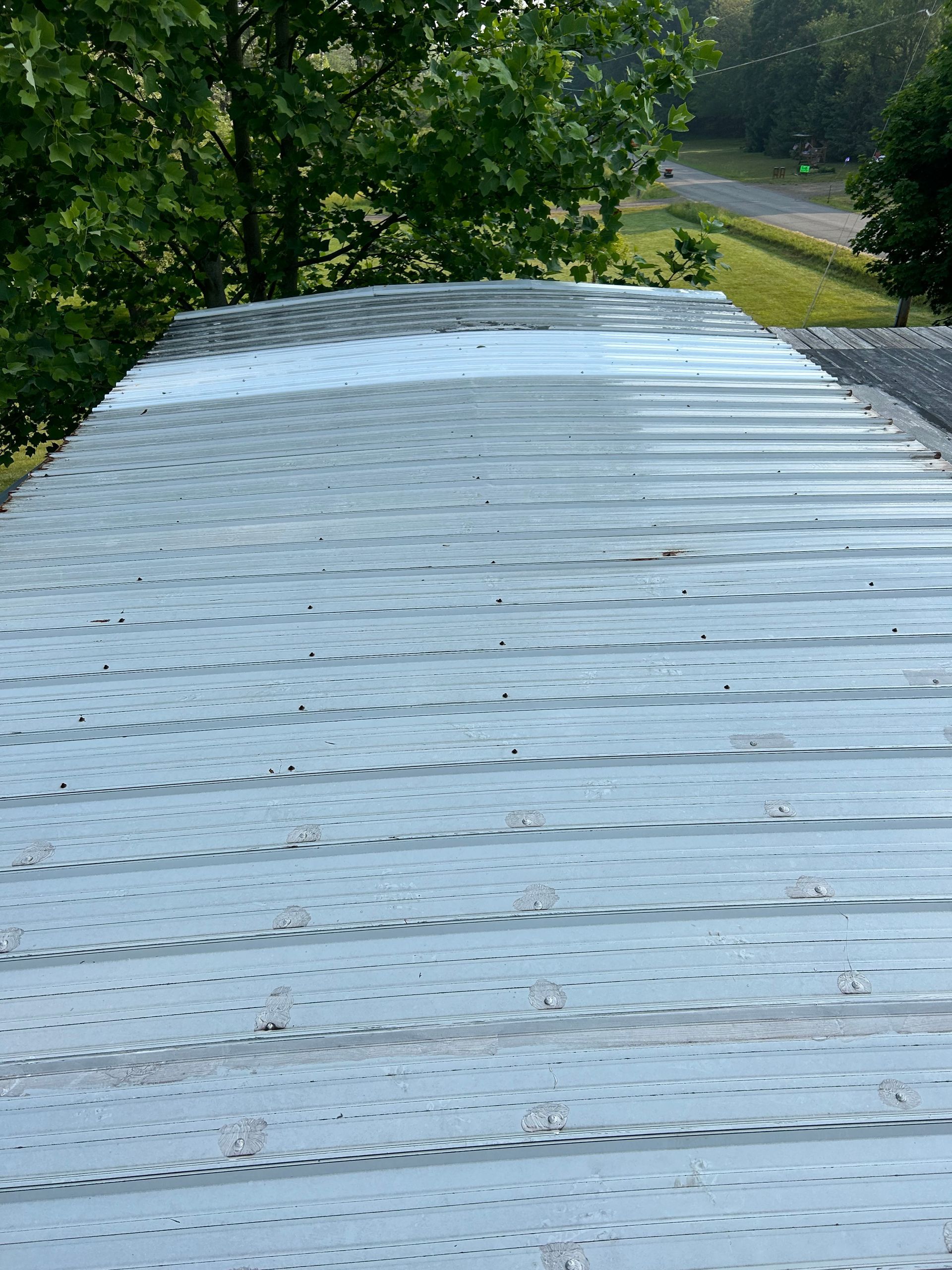 An aerial view of a building under construction with a white roof.