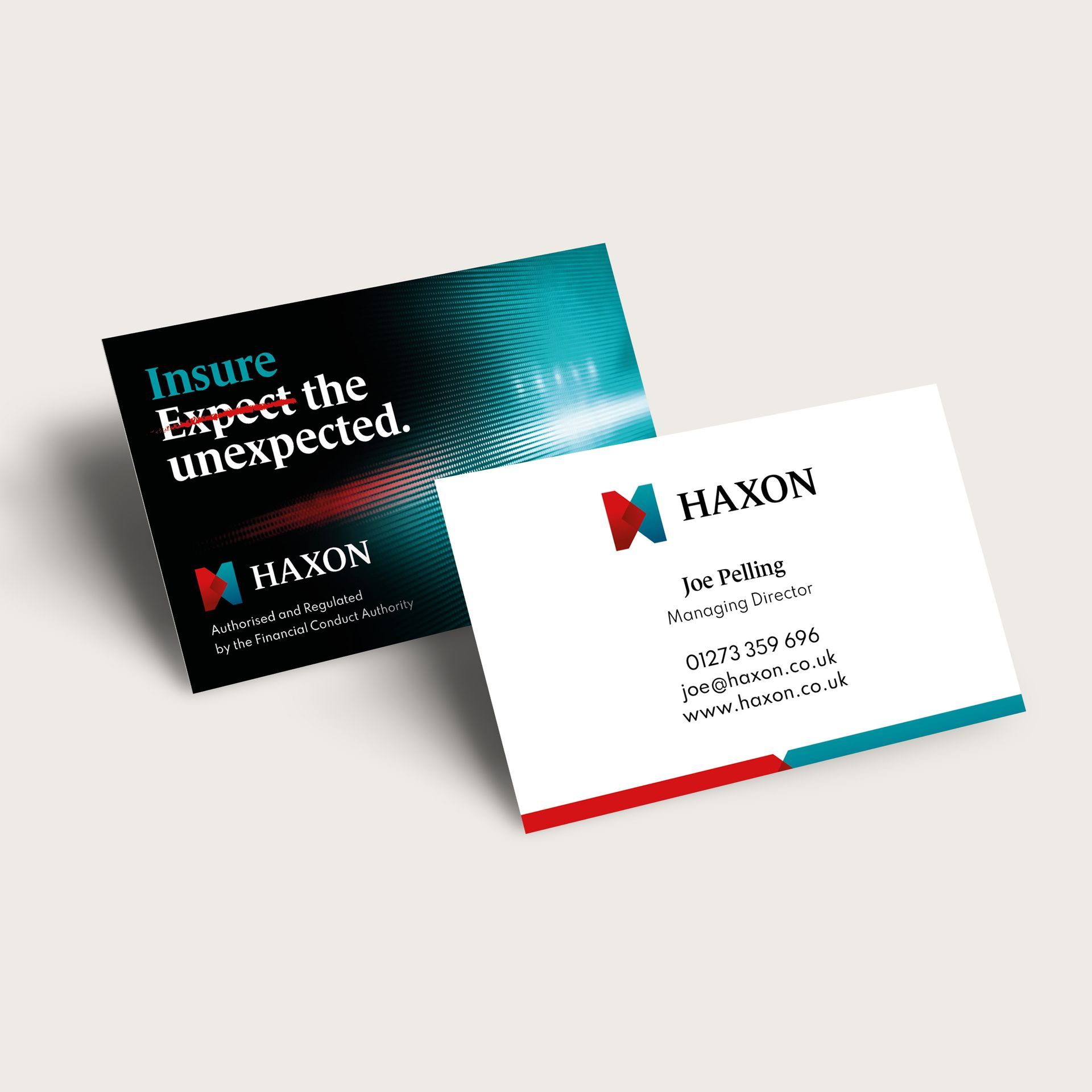 Two business cards are sitting on top of each other on a table.