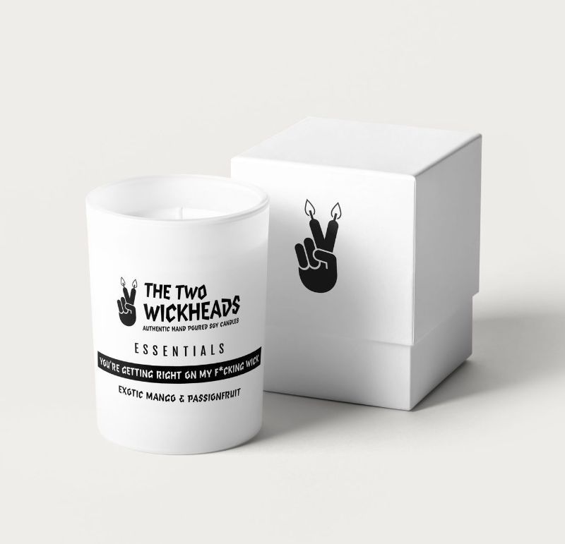 A white candle with the words the two wickheads essentials on it
