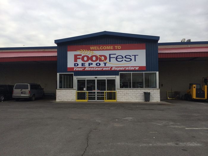 A Foodfest depot store with cars parked in front of it