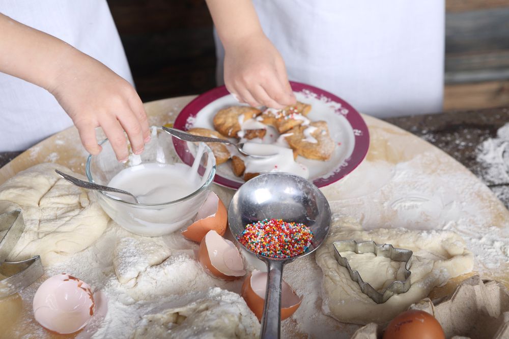 A person is preparing food on a table with eggs and sprinkles.