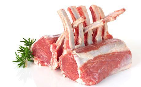 Raw lamb chops with rosemary on a white background.