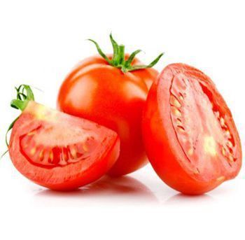 Two tomatoes are cut in half on a white surface.