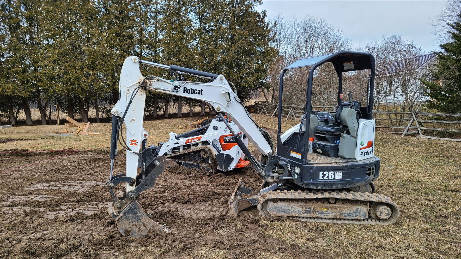 A bobcat excavator is parked on the side of the road.