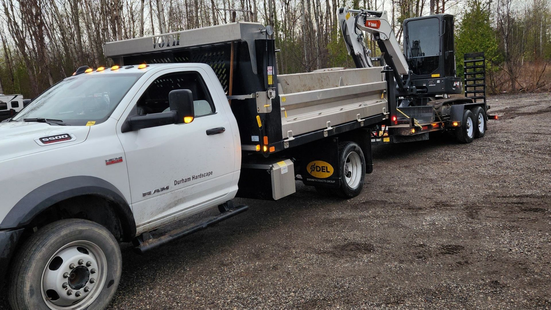 A bobcat excavator is parked in front of a house.