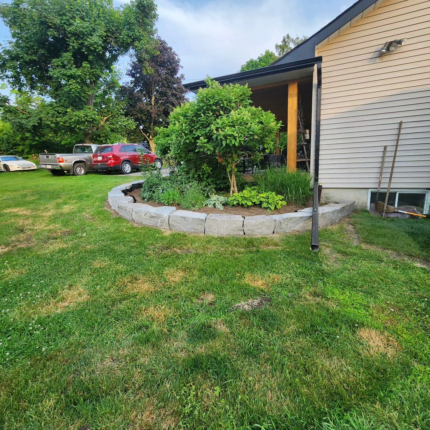 A house with a circular garden in front of it.
