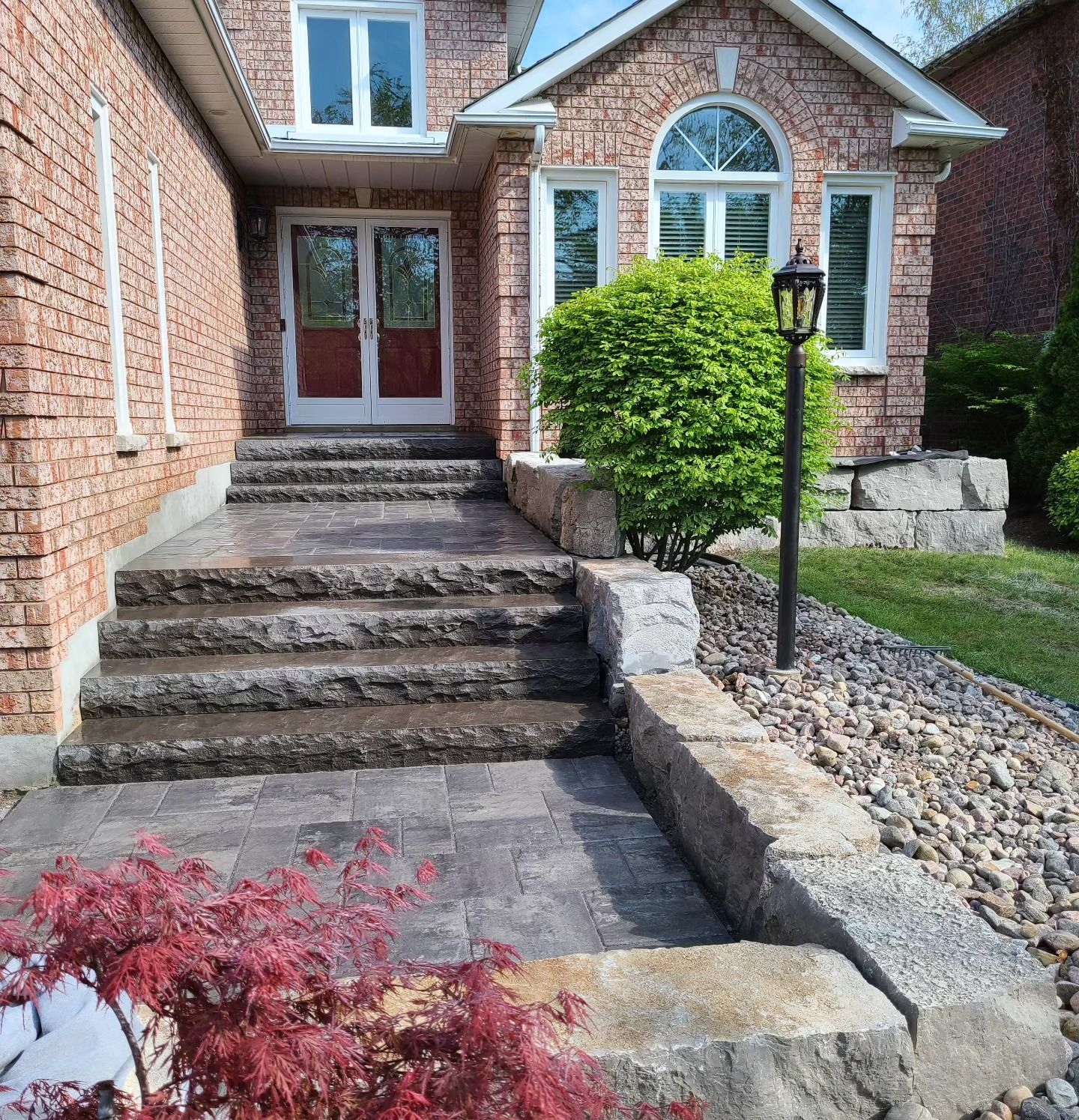 A brick house with stairs leading up to the front door