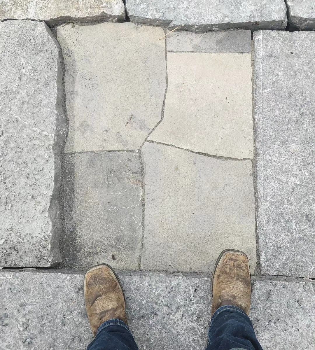 A person is standing on a cracked stone floor