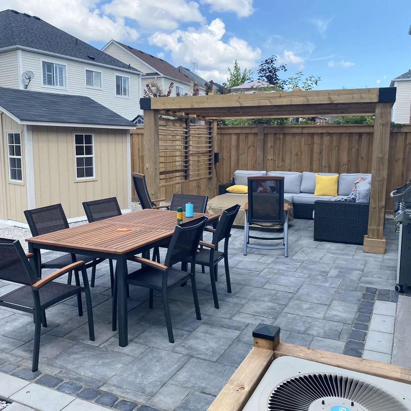 A patio with a table and chairs and an air conditioner