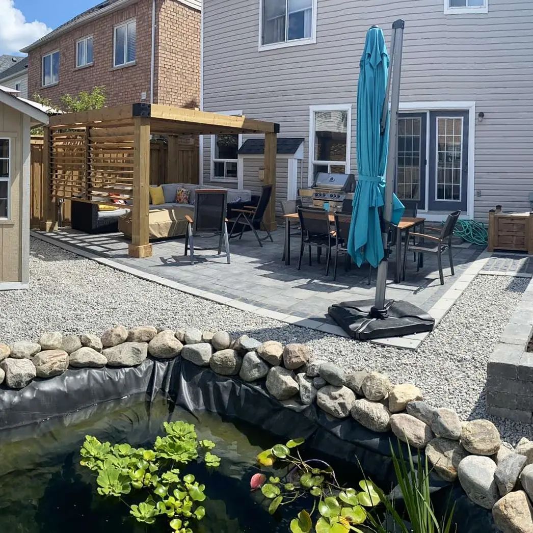 There is a pond in the backyard of a house.