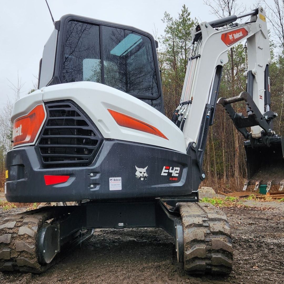 A bobcat excavator is parked in a dirt field
