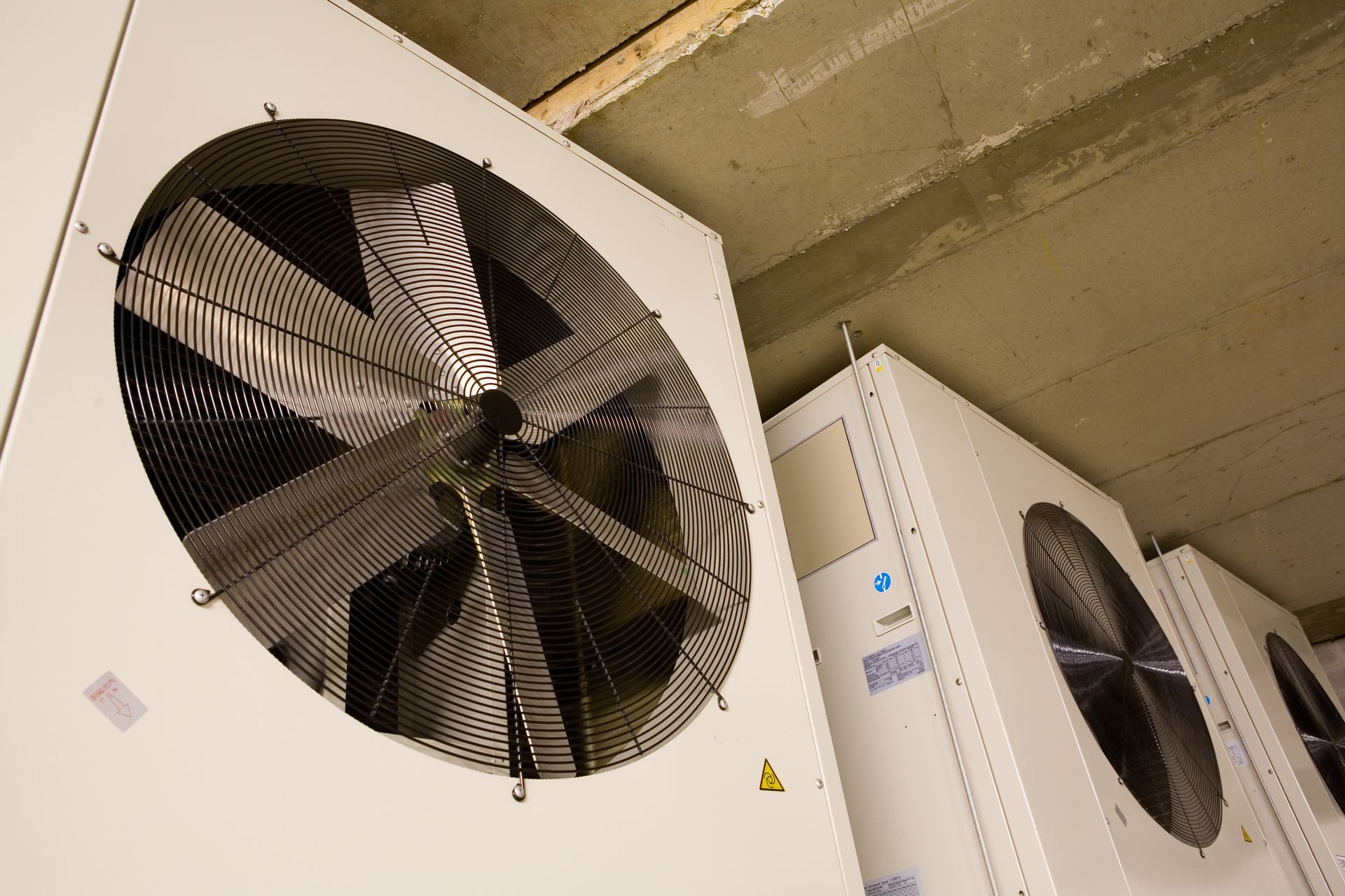 A large fan is hanging from the ceiling of a building