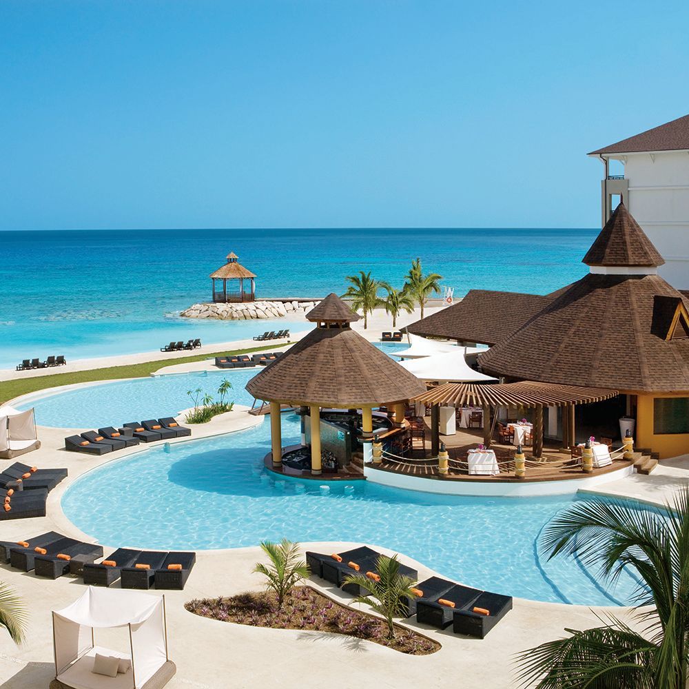 Blue-tiled pools surround a poolside bar with a conical roof.