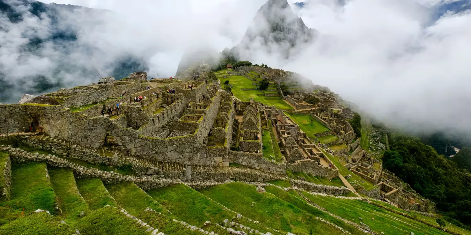 Machu Picchu stone terraces and ruins on a misty green mountainside