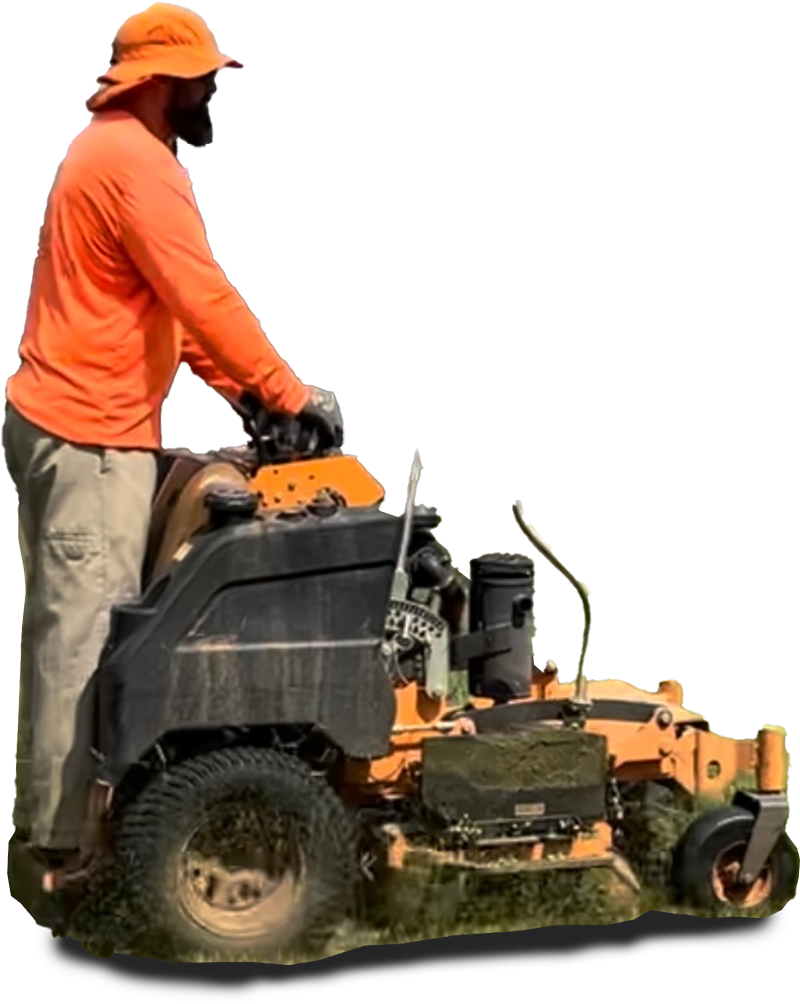 Man in orange shirt operating a zero-turn lawnmower, cutting grass.