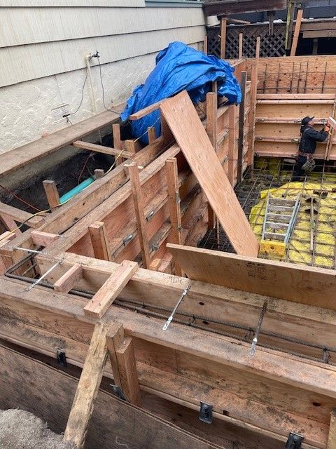 A wooden structure is being built in front of a house.
