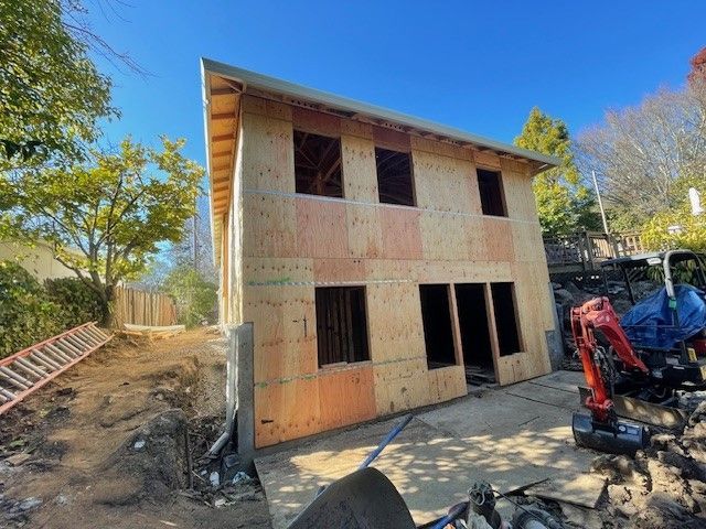 A house is being built with plywood and a ladder in the background.