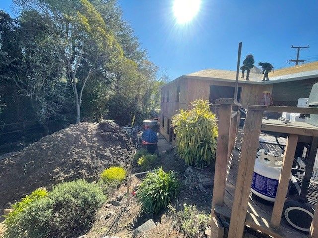 A man is working on the roof of a house.