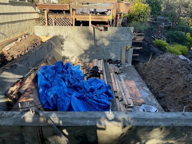 A pile of blue tarps is sitting on top of a pile of wood.