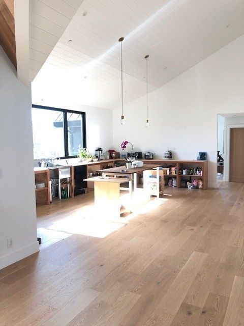 A kitchen with wooden floors and white walls