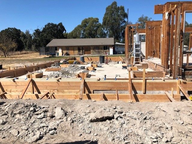A house is being built in the middle of a dirt field.