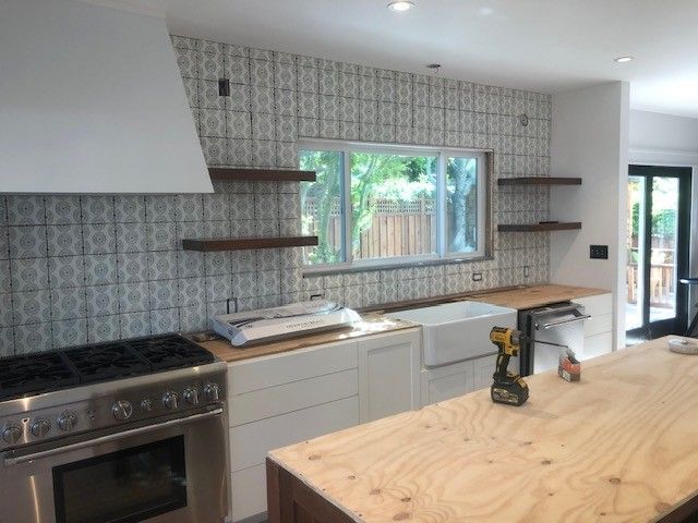A kitchen with stainless steel appliances and a wooden island.