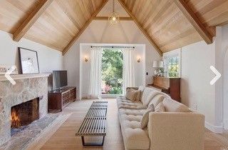 A living room with a couch , fireplace and television.