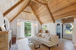 A living room with a vaulted ceiling and a couch and fireplace.