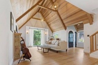 A living room with a vaulted ceiling and wooden floors.