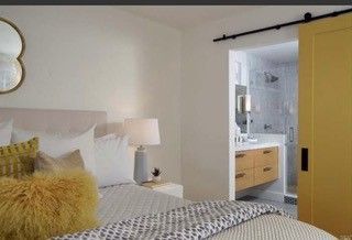 A bedroom with a sliding barn door leading to a bathroom.