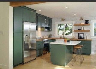 A kitchen with green cabinets and stainless steel appliances.
