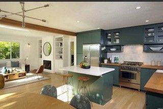 A kitchen with green cabinets and stainless steel appliances.