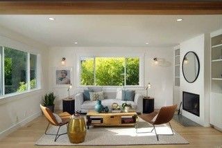 A living room with a couch , chairs , coffee table and fireplace.