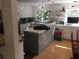 A kitchen with white cabinets and a large island in the middle of the room.