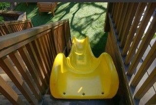 A yellow slide is going down a set of stairs.