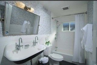A bathroom with a sink , toilet , tub and mirror.