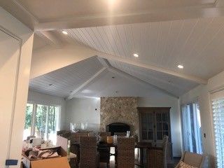 A living room with a vaulted ceiling and a fireplace.