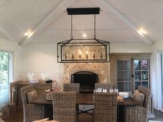 A dining room with a table and chairs and a fireplace.