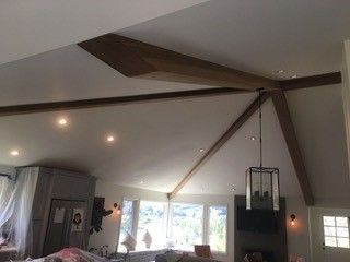 A living room with a vaulted ceiling and wooden beams.