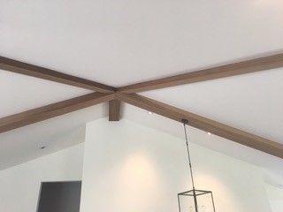 A ceiling with wooden beams and a lamp hanging from it.