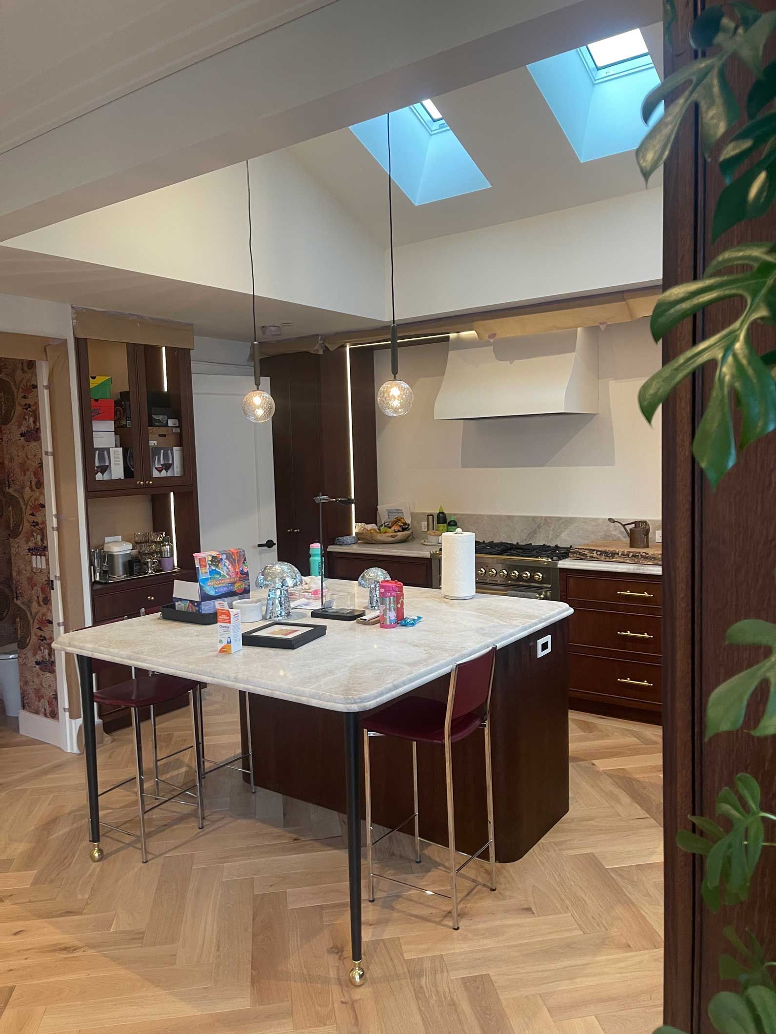 A kitchen with a table and chairs and a skylight in the ceiling.