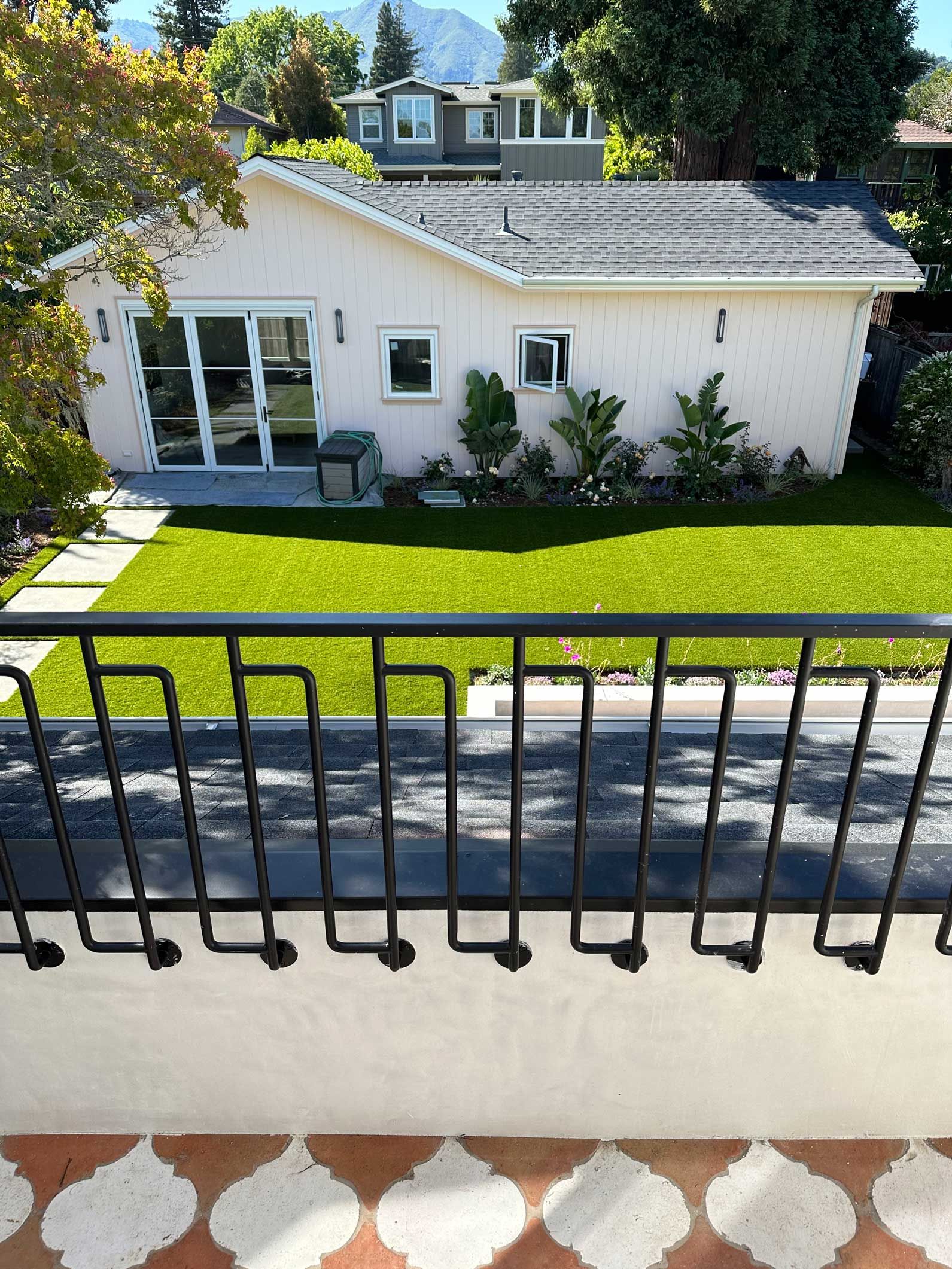 A view of a house from a balcony with a wrought iron railing