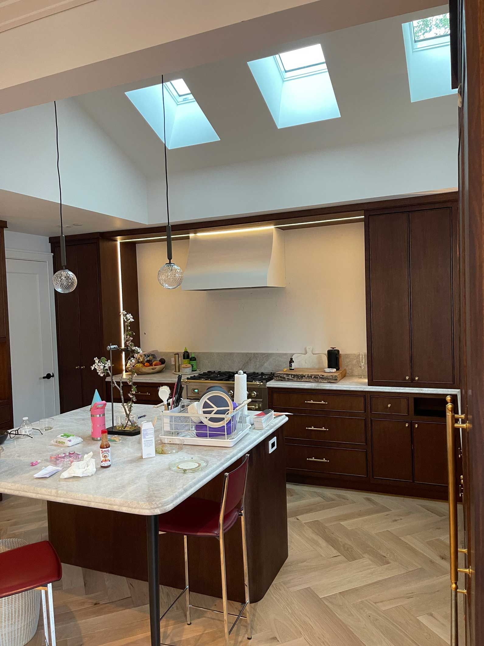 A kitchen with a table and chairs and a skylight in the ceiling.