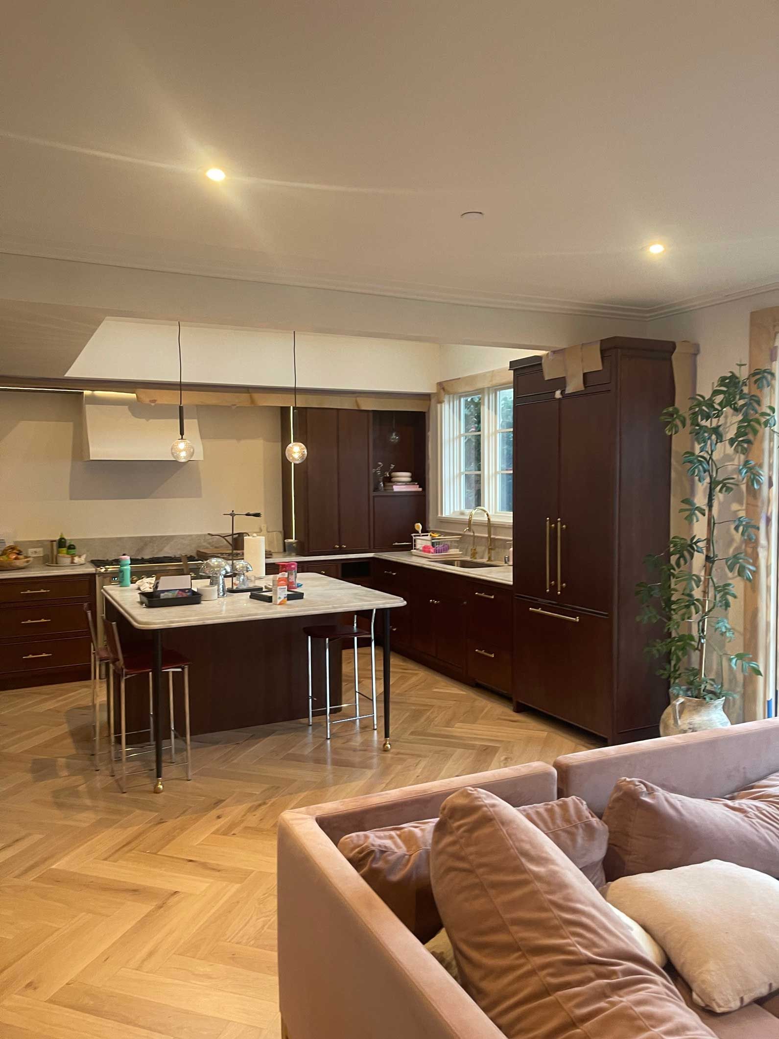 A living room with a couch and a kitchen in the background.