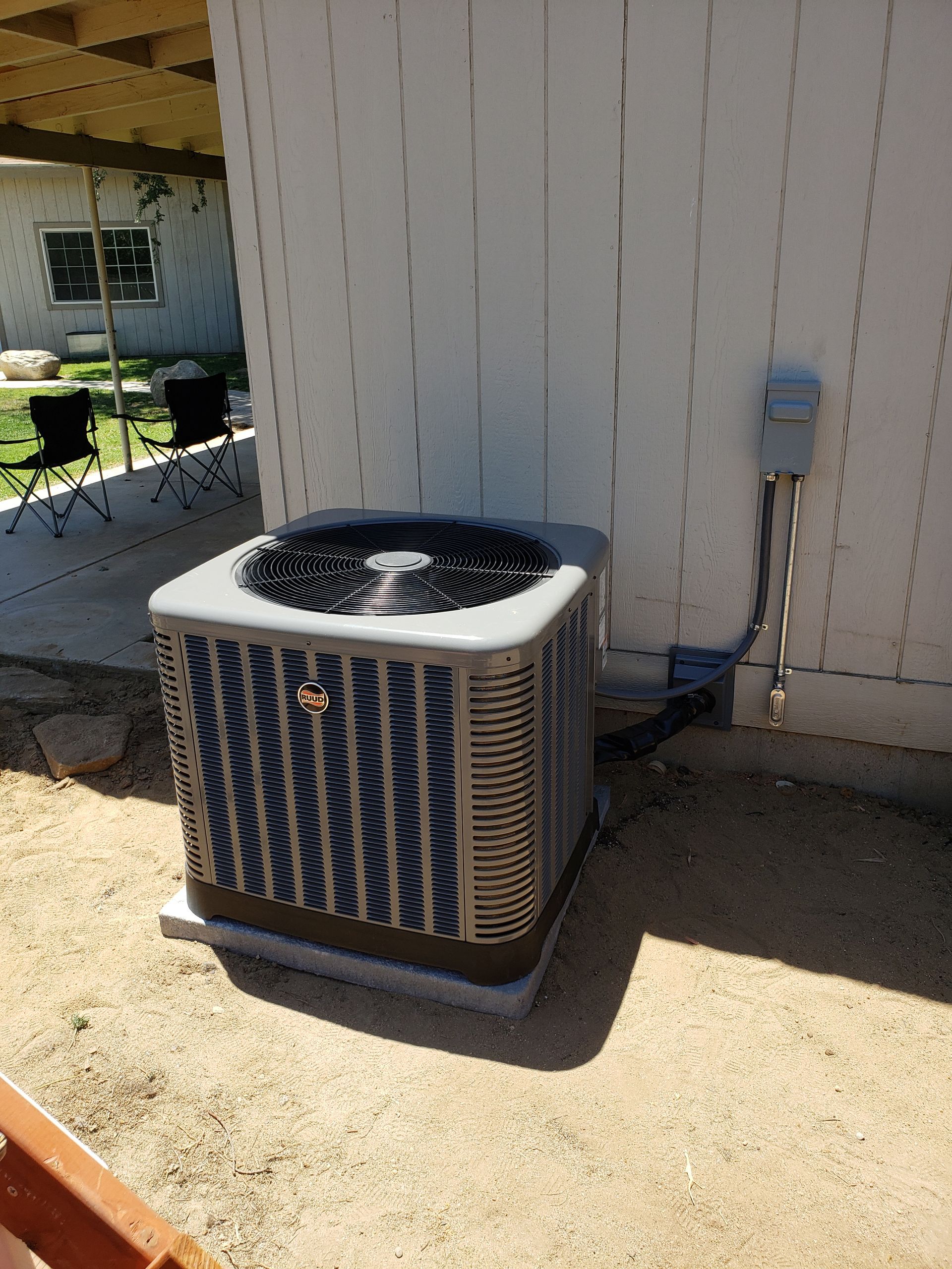 a large air conditioner is sitting outside of a house .