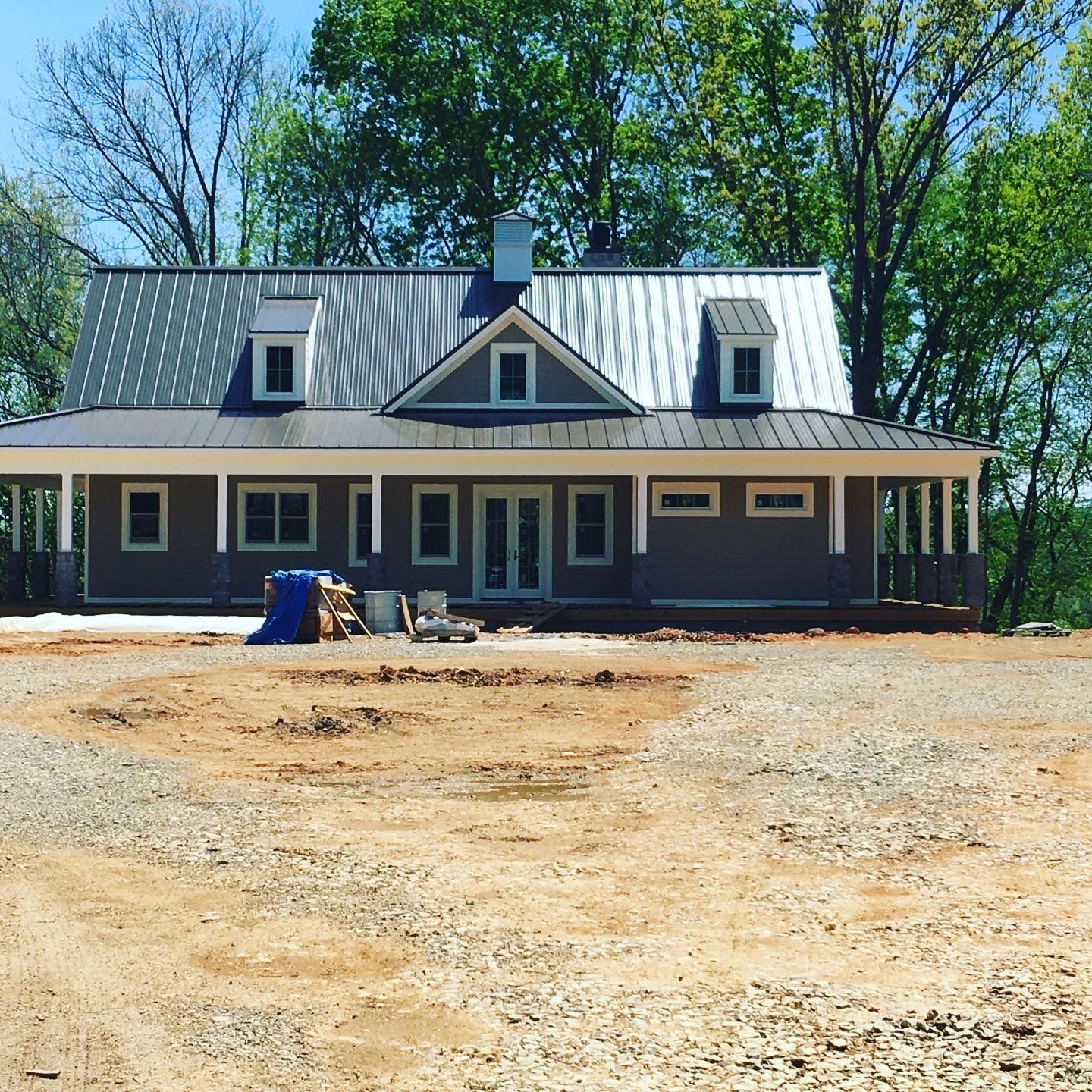A house that is being built with a lot of dirt in front of it