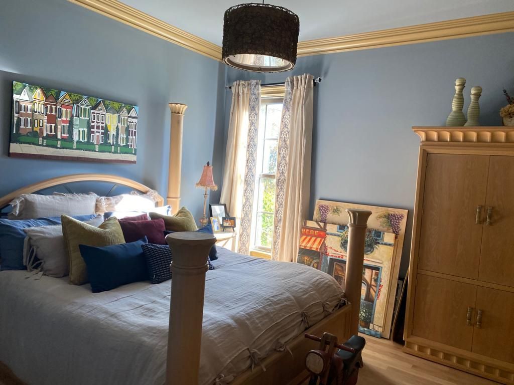 A bedroom with a bed and a painting on the wall