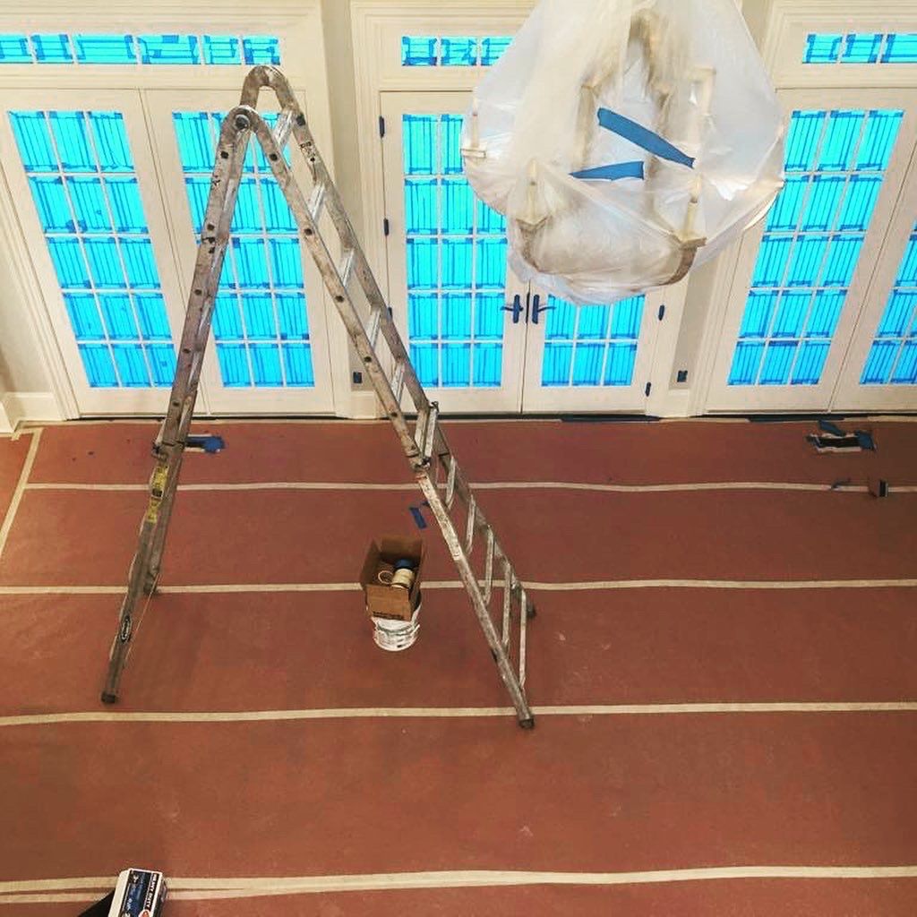 An aerial view of a room with a ladder and a light hanging from the ceiling