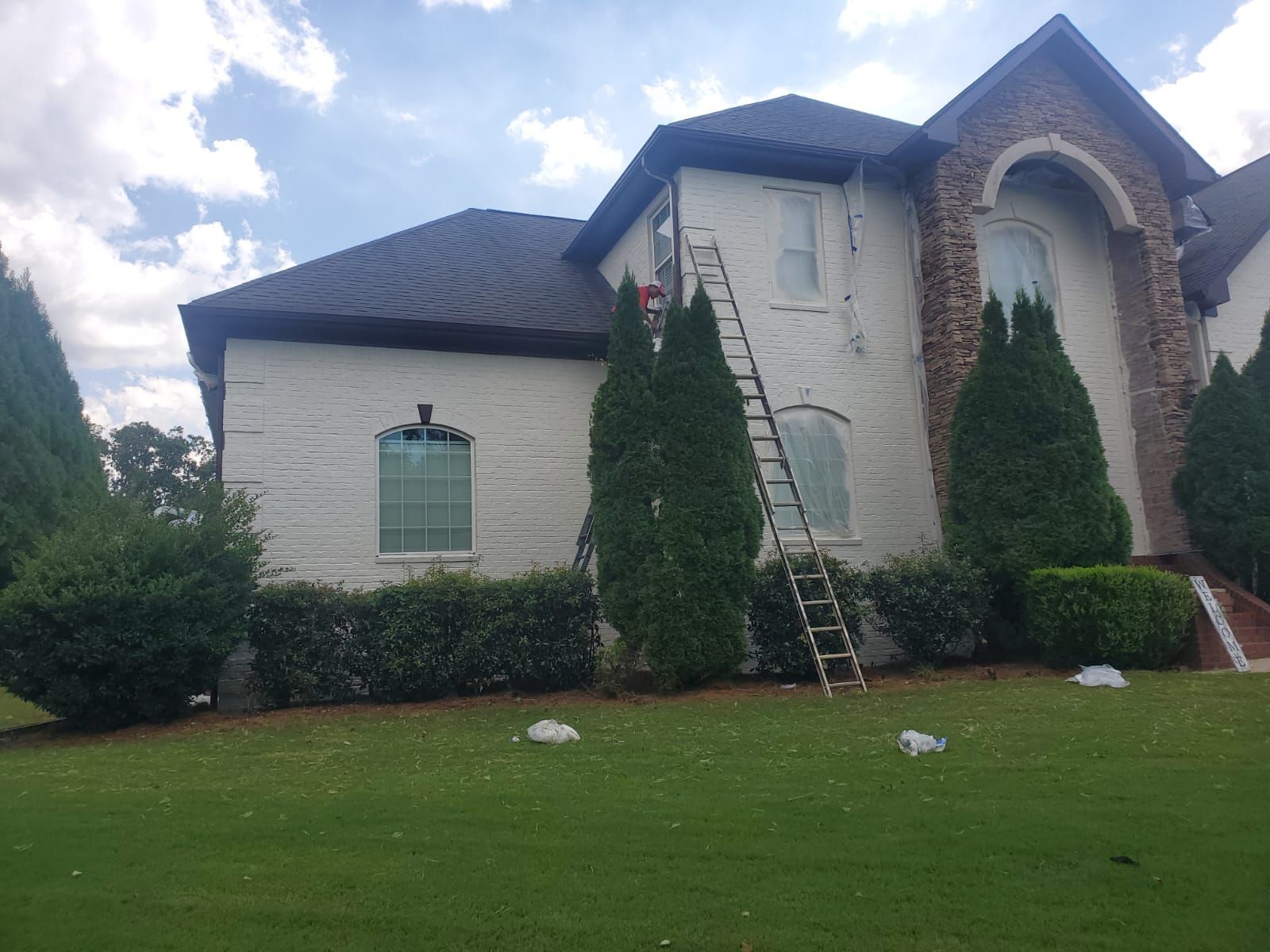 A large white house with a ladder in front of it.