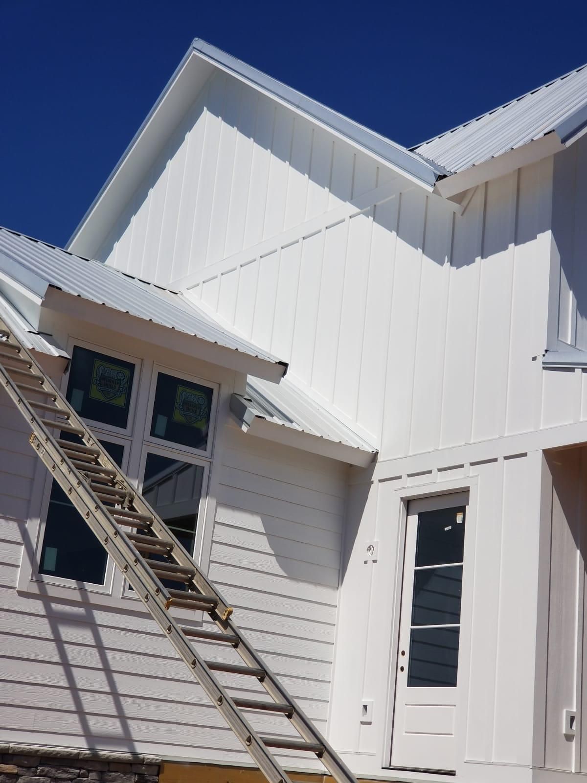 A white house with a ladder on the side of it